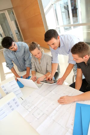 Educator with students in architecture working on electronic tablet